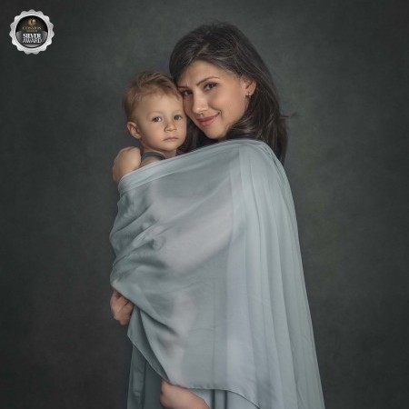 Mothers day Portrait of a young mom snuggling her little boy in a serene photo with blue tones taken at an Ottawa Ontario Photography studio 