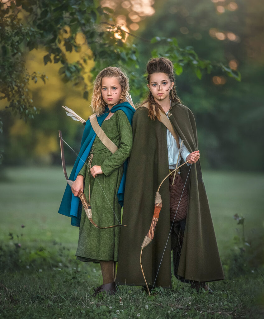 Two sisters dressed as fierce warriors in a custom outdoor children’s fantasy photography session with dramatic styling in Ottawa