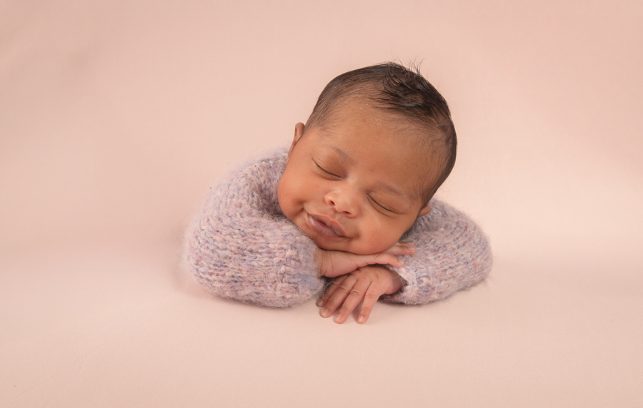 traditional newborn portrait of baby girl in lavender knit pajamas with soft pink accents, Ottawa session.