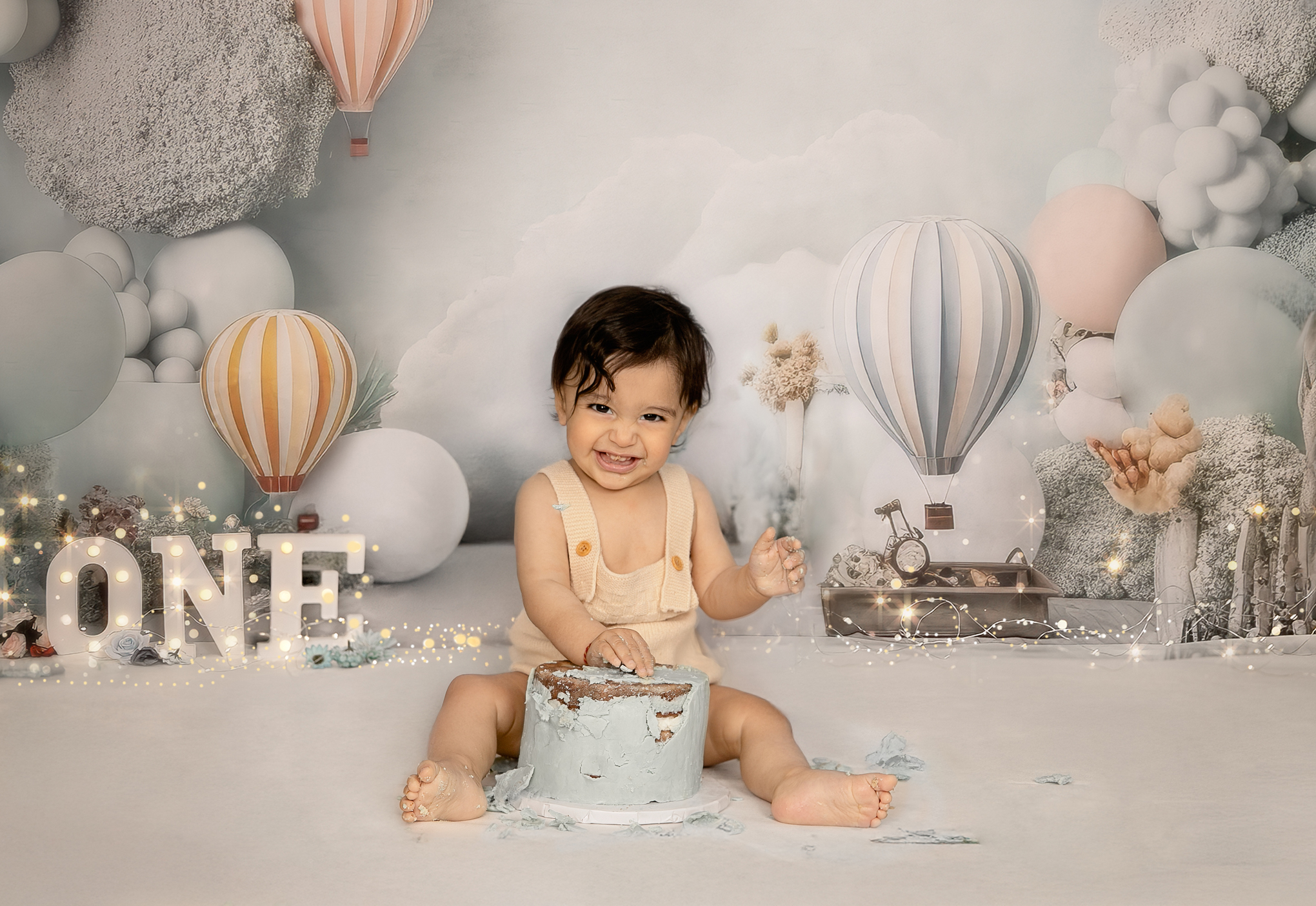 Baby sitting beside cake during first birthday cake smash Ottawa studio session