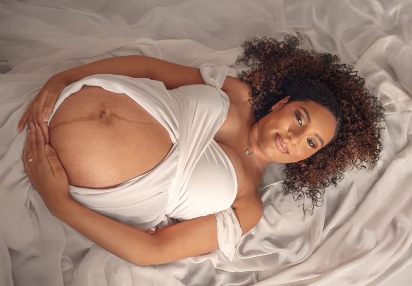 Mom-to-be posing in flowing silk fabric for a creative studio maternity portrait in Ottawa