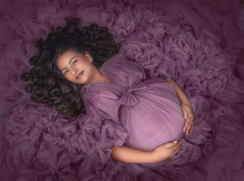 Pregnant woman wearing a soft maternity robe highlighting her baby bump in Ottawa studio maternity photography