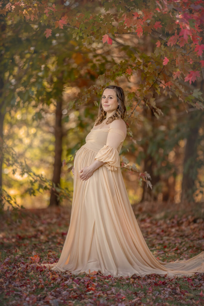 Expecting mother posing outdoors in a beautiful maternity dress surrounded by nature in Ottawa